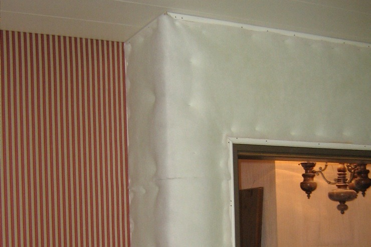 Wandbespannung mit Rot-creme gestreiftem Stoff während der Montage, wattierung ist schon montiert