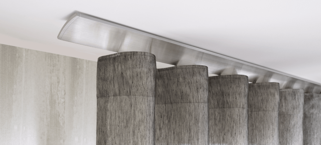 Graumelierter Vorhang an einer flachen, leichte gewölbten Wellenvorhangschiene vor heller Wand
