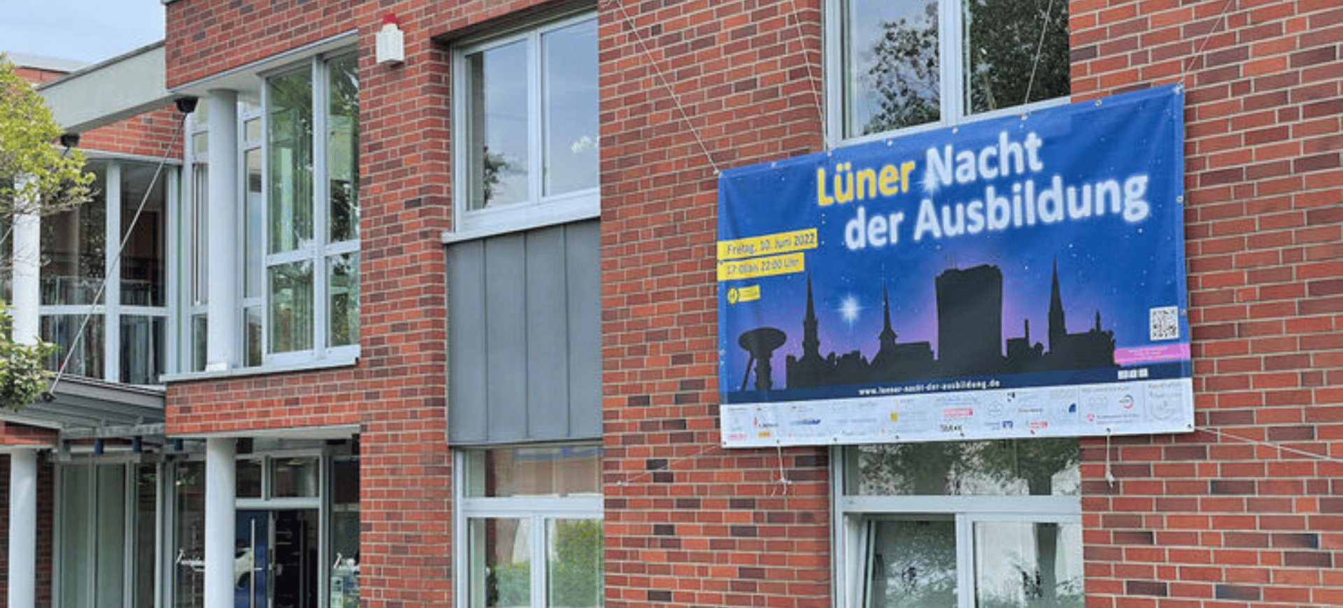 Beitragsbild Fassade des Firmengebäudes mit dem Banner für die Lüner Nacht der Ausbildung