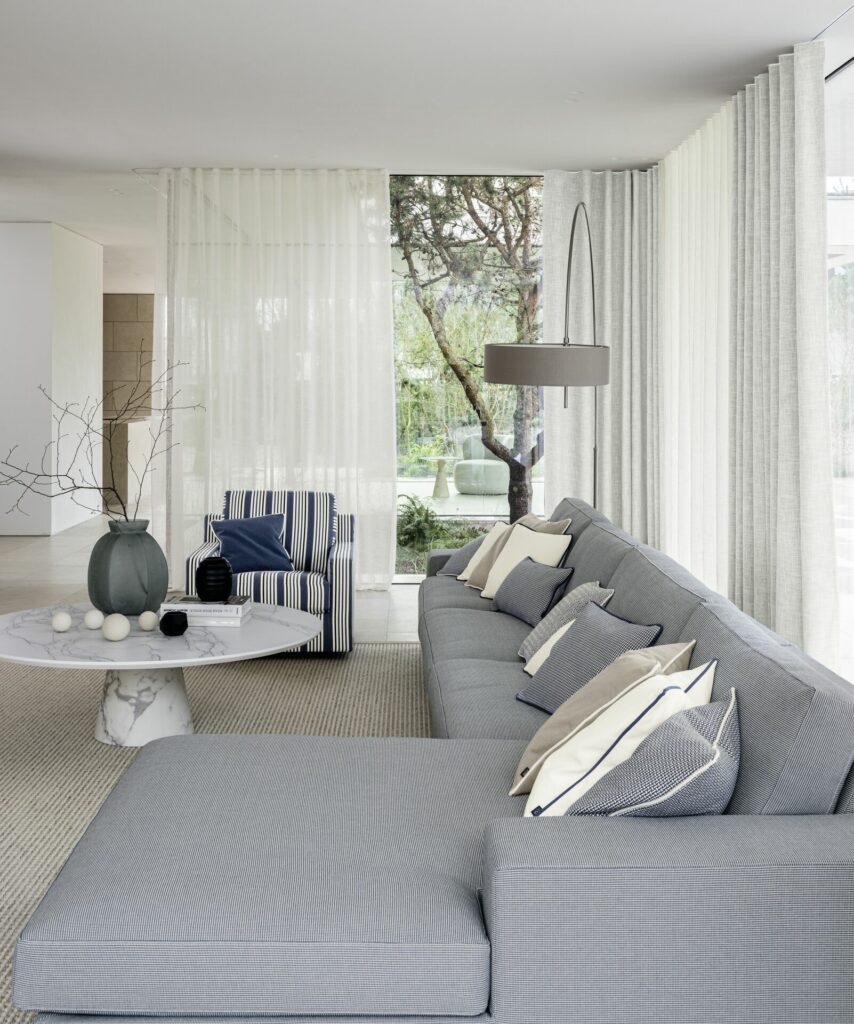 Halbtransparente Gardinen im Wohnzimmer mit grauer Couch