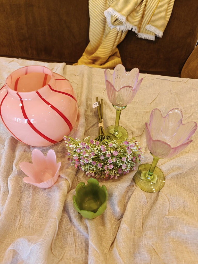 Rosefarbene Vase und Teelichthalter in Blötenform aus Glas dekoriert auf dem Tisch