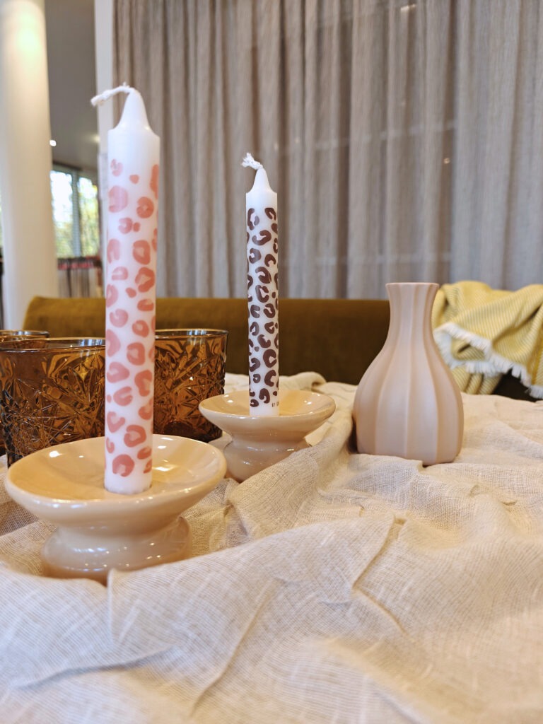 Kerzenhalter mit Kerzen im Leopardenlook und Vase dekoriert auf dem Tisch